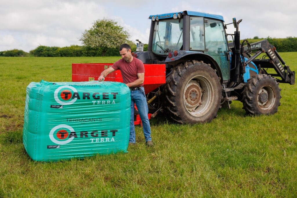 farmer opening bags of fertiliser